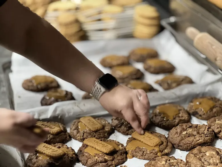 Mano con reloj decorando cookies