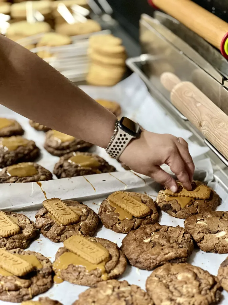 Brazo de persona con reloj cogiendo una cookie