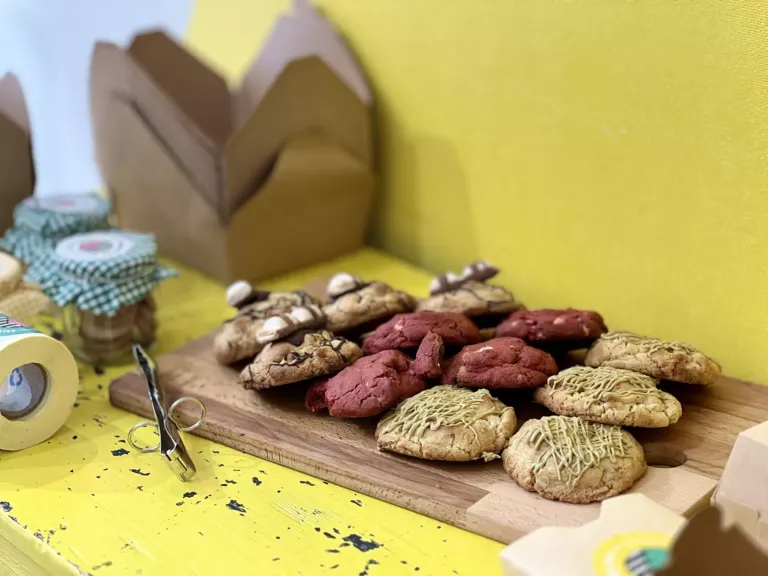 Cookies de distintos sabores sobre tabla de madera, utensillos de decoración